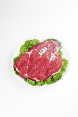 Fresh Raw Beef Steaks on White Plate with Lettuce Garnish - Premium Meat Photography
