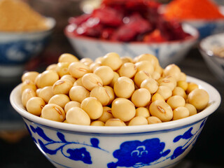 Soybeans in Traditional Ceramic Bowl with Assorted Grains and Legumes Background