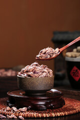 Traditional tea kernels in rustic bowl with wooden spoon and vintage teapot setup