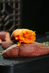 Fresh Roasted Sweet Potatoes with Orange Flesh on Dark Background
