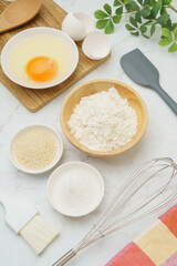 料理・お菓子づくりのイメージ(小麦粉・卵・塩・きび砂糖)・白い大理石背景