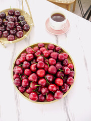 Fresh Shandong Cherries in Bamboo Baskets with Tea on Marble Table - Healthy Summer Fruit Still Life