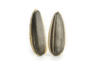 Two striped sunflower seeds isolated on white background showing natural seed texture and patterns