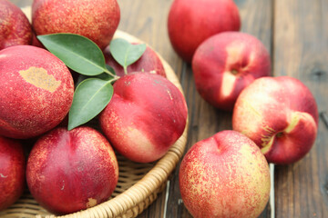 Fresh Red Nectarines in Wicker Basket on Rustic Wood Background - Healthy Stone Fruit Display