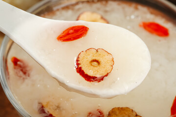 Asian White Soup with Red Dates on Ceramic Spoon - Traditional Comfort Food