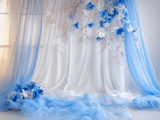 Elegant backdrop adorned with flowing blue and white fabrics and delicate floral arrangements showcasing soft colors and textures