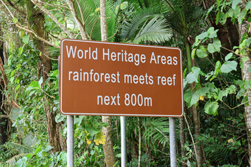 World Heritage Areas rainforest meets reef next 800m sign amongst palm trees near Mission Beach in Queensland, Australia
