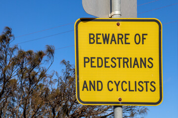 beware of pedestrians and cyclists sign and blue sky