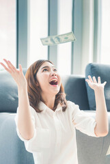 Vertical Horizon Happy young asian woman holding dollar money throwing falling down celebrate...