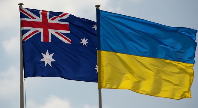 Australian and ukrainian flags waving against a cloudy sky background