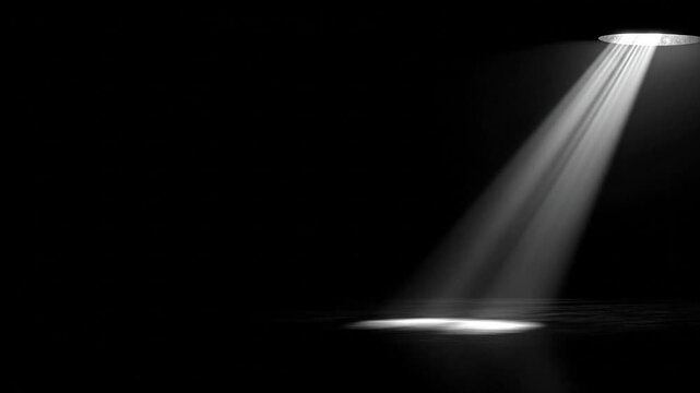 Dramatic overhead spotlight illuminating abstract space with copy area