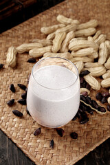 Peanut Butter Smoothie with Fresh Peanuts and Raisins on Bamboo Mat