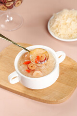Silver Tree Ear Fungus Soup with Goji Berries in White Bowl on Wooden Board
