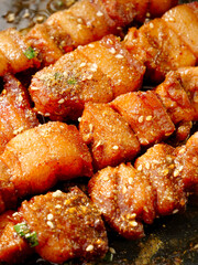 Crispy Streaky Bacon Pieces Cooking with Herbs and Spices in Pan