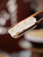 Fresh Tofu Block in Wooden Chopsticks Ready for Asian Cooking