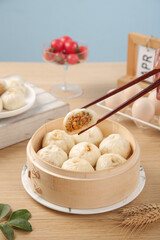 Traditional Chinese Xiaolongbao Soup Dumplings in Bamboo Steamer with Chopsticks