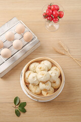 Chinese Steamed Buns Xiao Long Bao in Bamboo Steamer with Fresh Ingredients on Wooden Table