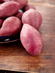 Fresh Red Sweet Potatoes on Rustic Wooden Background - Organic Root Vegetables for Healthy Cooking and Nutrition