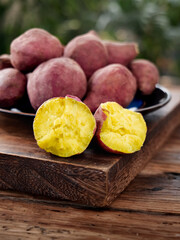 Fresh Yellow Potatoes Cut in Half Showing Golden Flesh on Rustic Wooden Board