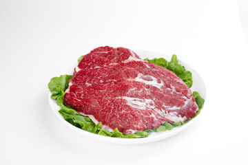 Raw Beef Brisket Cut Slices on Plate with Lettuce Garnish