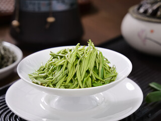 Xinyang Mao Jian Green Tea Leaves in Cup with Traditional Chinese Teapots for Brewing Ceremony