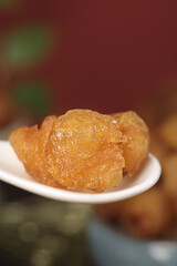 Dried Longan Fruit Without Shell Showing Nucleus on White Plate - Traditional Asian Healthy Snack