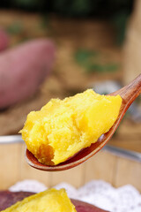 Fresh turmeric spice paste on wooden spoon - natural golden cooking ingredient