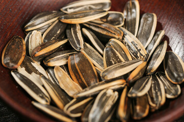 Roasted Sunflower Seeds with Black Striped Shells in Wooden Bowl - Healthy Snack Food Ingredient