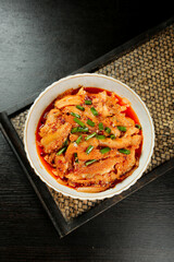 Spicy Red Tripe Dish with Chili Oil and Green Onions in Traditional Asian Bowl