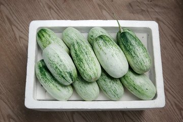 Fresh Green Cucumbers in White Container on Wooden Background - Healthy Organic Vegetables