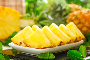 Fresh Sliced Pineapple from Zhanjiang China with Mint Garnish on White Plate