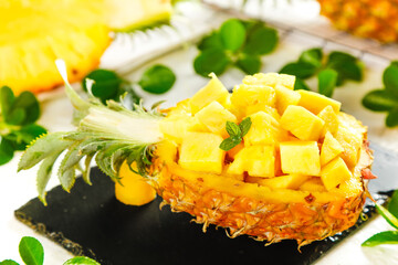 Fresh Cut Pineapple Bowl with Sweet Chunks and Mint Garnish on Black Slate