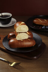 Handmade Lye Bread Rolls with Golden Crust on Dark Wooden Table with Coffee