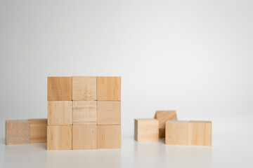 Wooden cubes arranged in solid square block on white background symbolizing structure, stability, order