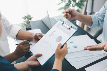 Business teamwork reviewing financial report with charts and graphs in modern office, colleagues...