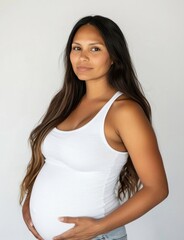 American indian pregnant woman wearing white tank top and baggy jeans portrait female photo.