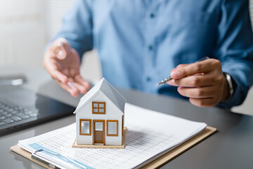 mortgage, calculator, loan, interest, rate, payment, amortization, Businessman analyzing house model with financial documents, representing mortgage loan, housing finance, and affordability planning.