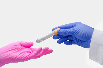 A laboratory technician hands another a venipuncture blood sample tube.