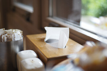 Tissue box on a wooden table by the window in a cozy cafe