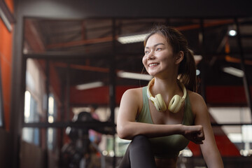 Fitness, happy woman and ready in gym with headphones, relax for workout, smile and music for exercise.