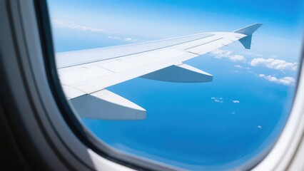 Looking out from the airplane window, the wing, against the clear blue sky, shows the unique perspective and vast artistic conception of air travel.