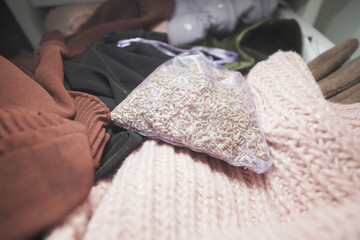 Clothes and a bag of lavender rest on a soft blanket