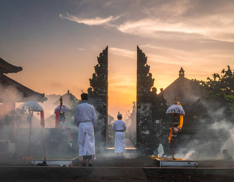 Balinese Hindu People Praying at Temple Gate During Sunrise Ceremony