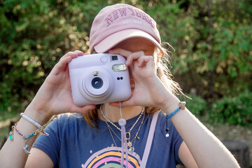 little girl outdoors on a sunny day with film camera