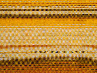 Fabric scarf background. Fragment of woven wool fabric. Ethnic patterns with brown and yellow lines
