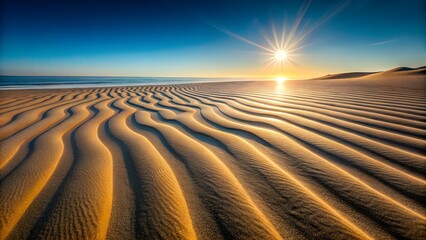 Naklejka premium Golden Sunset Over Rippled Sand Dunes at the Coast with Sparkling Ocean and Clear Blue Sky Creating a