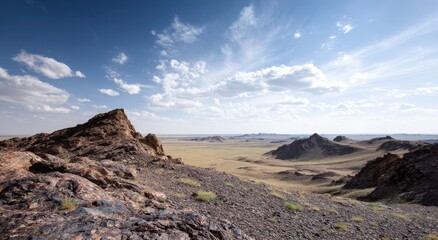 Vast desert landscape with rocky hills and blue sky