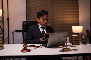 A lawyer is reading a book about law in the office.
