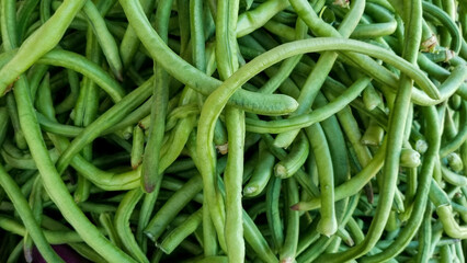 A vibrant heap of fresh green beans with rich green color and natural texture, ideal for food,...