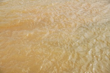 Muddy river water texture background. Waves on the water. Nature empty lake surface with waves for a background
